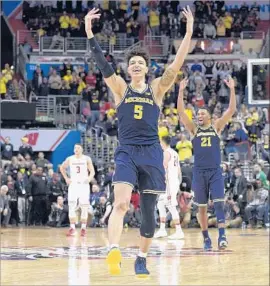  ?? Nick Wass Associated Press ?? WITH VICTORY moments away, Michigan’s D.J. Wilson, foreground, and Zak Irvin begin an on-court celebratio­n during the Big Ten title game.