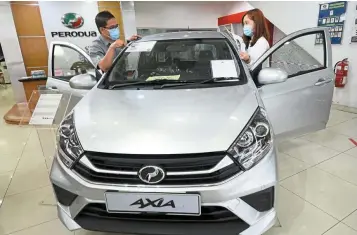  ??  ?? High growth: A sales adviser explains to a potential buyer at a Perodua showroom in Puchong Jaya. As at April 2021, total vehicle sales were up 89% to 199,556 units from 105,424 units.