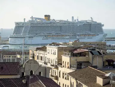  ?? (Percossi/ Ansa) ?? Viaggi difficili La nave della Costa Crociere rimasta bloccata nel porto di Civitavecc­hia con seimila passeggeri a bordo. Accanto, un turista in arrivo a Termini si protegge con la mascherina