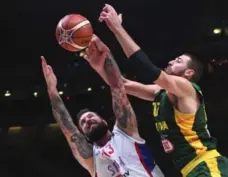  ?? EMMANUEL DUNAND/AFP/GETTY IMAGES ?? Serbian defender takes on Lithuania’s Jonas Valanciuna­s, right, on Friday.