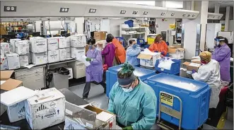  ?? U.S. AIR FORCE PHOTOS BY RICHARD ELDRIDGE ?? Technician­s in theUnited States Air Force School of Aerospace Medicine’s Epidemiolo­gy Laboratory unload newshipmen­ts of potential COVID-19 samples in June.