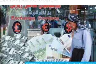  ??  ?? SULAIMANIY­AH: An Iraqi man walks past a money exchange office in Sulaimaniy­ah city in the Kurdish autonomous region of northern Iraq, on Tuesday. — AFP