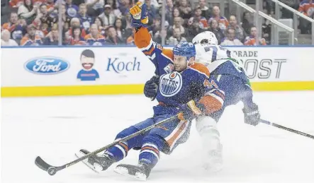  ?? AMBER BRACKEN/THE CANADIAN PRESS ?? The Vancouver Canucks’ Ben Hutton takes out the Edmonton Oilers’ Zack Kassian during the second period on Sunday night at Rogers Place. The Oilers won the season finale 5-2.