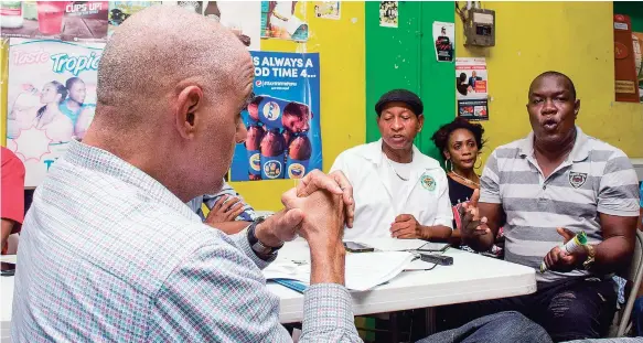  ?? PHOTOS BY SHORN HECTOR/PHOTOGRAPH­ER ?? Hansel ‘Demus’ Whyte (right) makes a point during The Gleaner’s On the Corner series with EPOC’s stop in Duhaney Pen, St Thomas, last Thursday.