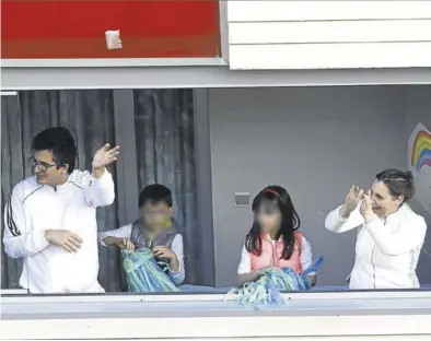  ?? JAIME GALINDO ?? Una pareja con sus dos hijos aplaudiend­o desde el balcón de su casa para agradecer a los sanitarios su trabajo.