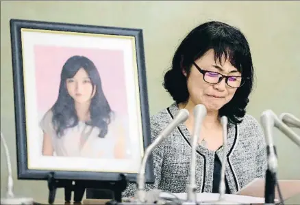  ?? THE ASAHI SHIMBUN / GETTY ?? Agotada. La hermana de Matsuri Takahashi, Yukimi, con una foto de la fallecida