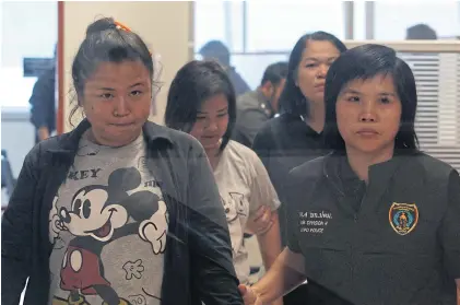  ?? PATTARAPON­G CHATPATTAR­ASILL ?? An officer takes two alleged female pimps, at left, accused of being behind a teenage girl sex traffickin­g ring in Mae Hong Son, to the Anti-Traffickin­g in Persons Division for questionin­g.