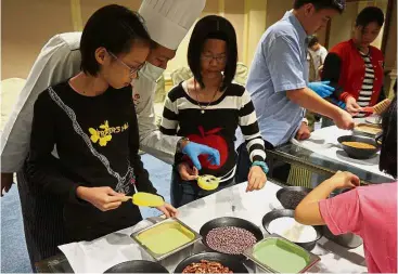  ??  ?? Students were shown how to mould ice cream by chef Mohd Rodzee (in white hat).