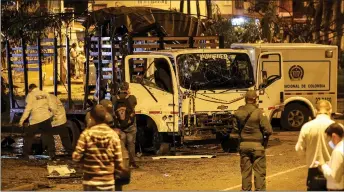  ?? — AFP photo ?? Security personnel inspect a national police truck destroyed by an explosive device in Cali, Colombia.