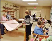  ?? BOB KEELER — MEDIANEWS GROUP ?? Cindy Keay, right front, and other volunteers sew comforters at the MCC Material Resource Center in Franconia. At left, the comforters are pinned to prepare for sewing.