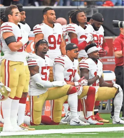  ?? SHANNA LOCKWOOD/USA TODAY SPORTS ?? 49ers outside linebacker Eli Harold (57), strong safety Eric Reid (35) and wide receiver Marquise Goodwin (11) kneel for the national anthem before a game in December.