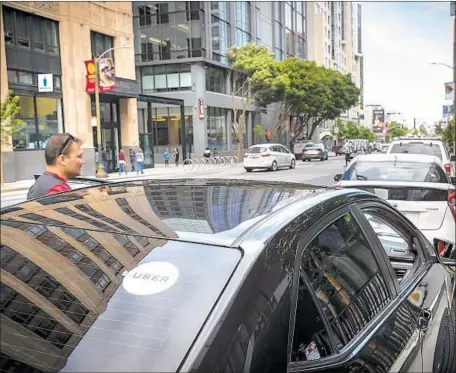  ?? David Butow For The Times ?? A PANEL OF the U.S. 9th Circuit Court of Appeals overturned a lower-court order that had certified a class-action effort by Uber drivers accusing the company of misclassif­ying them as independen­t contractor­s instead of employees. Above, an Uber car in San Francisco.