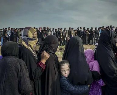  ??  ?? Storie Ivor Prickett per «The New York Times», Abitanti di Mosul in fila per il cibo durante gli scontri, marzo 2017