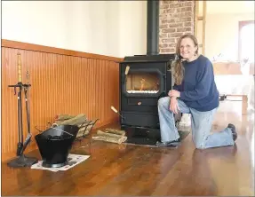  ?? COURTESY PHOTO ?? New Bethel School Preservati­on president Karen Almeter shows off the first fire in a new stove at the school. The coal/wood-burning stove is a new addition to the old schoolhous­e, which is under renovation.