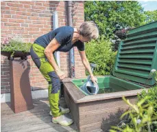  ?? FOTO: BENJAMIN NOLTE/DPA ?? Wer Regenwasse­r sammelt, kann seinen Garten damit bewässern – wichtig ist dann aber ein Deckel für den Wasserspei­cher.