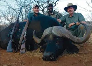  ??  ?? ABOVE LEFT: At dawn, (L-R) PH Blackie Swart, author and his son Tiaan Nel ready for the hunt. ABOVE RIGHT: (L-R) Blackie Swart, the tracker Brighton and the author with his buffalo.