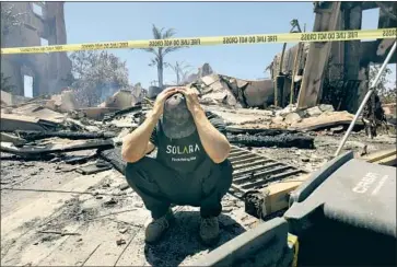  ?? Carolyn Cole Los Angeles Times ?? MATTHEW VOGEL, 39, crouches in front of his parents’ ruined home Thursday in Coronado Pointe. His mother, Sandy Vogel, said: “We’ll rebuild and we’ll see if we want to stay here. Maybe it’ll be too hard.”