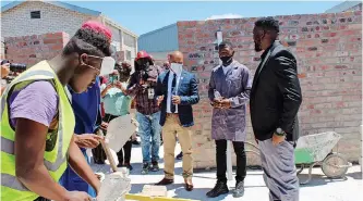  ?? SUPPLIED ?? DEPUTY minister Buti Manamela, College of Cape Town Thornton campus manager Ryan Marsh and bricklayin­g facilitato­r Mihle Mvelakubi this week. |