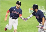  ?? Mitchell Layton / Getty Images ?? Boston’s Michael Chavis, left, celebrates scoring on a wild pitch in the 10th inning with Xander Bogaerts on Saturday.