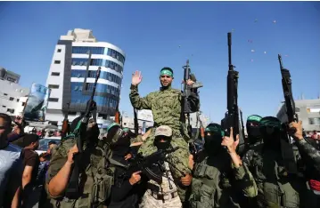  ??  ?? HAMAS MEMBERS celebrate in Gaza in July after one of their prisoners was released by Israel.