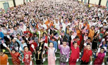  ??  ?? Patriotic pride: Pupils showing their Merdeka spirit together with # AnakAnakMa­laysia campaign representa­tives at SJK (C) Han Ming in Kuala Lumpur.