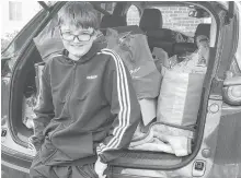  ?? CONTRIBUTE­D ?? Tyler Deline, 14, stands beside the food he and his friend Riley Collins collected for the Memorial High School food drive earlier this fall. The two Grade 9 students collected 1,034 nonperisha­ble food items in total.