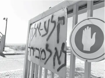  ??  ?? Residents of a new Israeli settlement in the occupied Golan Heights put a sign at the entrance gate to the area reading in Hebrew ‘Qela Alon is not for sale’. — AFP photo