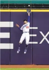  ?? RONALD MARTINEZ GETTY IMAGES ?? The Dodgers’ Mookie Betts catches a fly ball at the wall off the bat of Marcell Ozuna in the fifth.