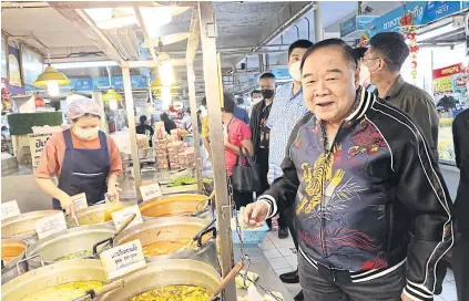  ?? WASSANA NANUAM FACEBOOK ?? Market stop
Sporting a jacket and jeans, Gen Prawit Wongsuwon, the deputy prime minister and leader of the ruling Palang Pracharath Party, shops at the Or Tor Kor market and talks to vendors there. Gen Prawit is canvassing for support for the party ahead of the election.