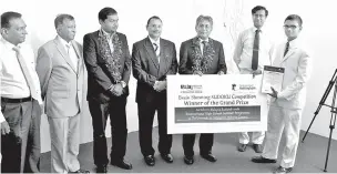  ??  ?? Nimsara Seneviratn­e, the grand prize winner from Royal College receiving the award from the High Commission­er of Malaysia to Sri Lanka