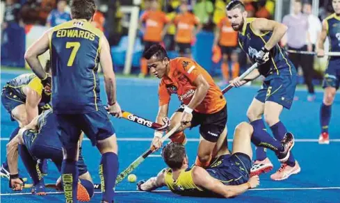  ?? PIC BY MUHAIZAN YAHYA ?? Malaysia’s Firhan Ashaari (second from right) attempts to go past three Australia players during their Azlan Shah Cup match on Sunday. Australia won 6-1.