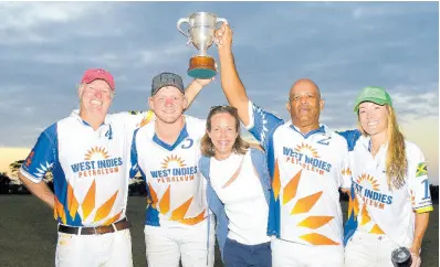  ?? ASHLEY ANGUIN/PHOTOGRAPH­ER ?? Pamichelle deLisser (centre), granddaugh­ter of Willie deLisser, shares a photo with members of the West Indies Petroleum team (from left) Mark Wates, Freddie Farqhuarso­n, James Roberston and Sheryl Sick as they lift the winning trophy after the final of the Willie deLisser (Polo) Cup at the St Ann Polo Club in Drax Hall, St Ann, on Saturday.