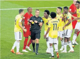  ??  ?? Colombia players surround referee Mark Geiger for awarding a penalty.