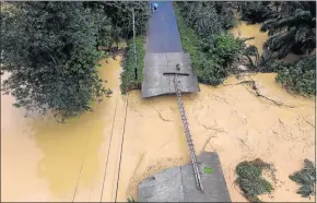  ?? Picture: REUTERS ?? ROAD TO NOWHERE: A torrent of muddy floodwater­s rages beneath a bridge damaged by floods in the Chai Buri district of Surat Thani province in Thailand