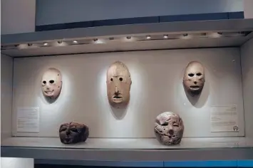  ?? MAYA ALLERUZZO/AP ?? A Neolithic mask loaned by American billionair­e Michael Steinhardt, center, is displayed at the Israel Museum in Jerusalem. The artifact was among 180 recently surrendere­d by Steinhardt to avoid prosecutio­n in the United States.