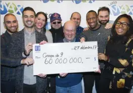  ?? GRAHAM HUGHES, THE CANADIAN PRESS ?? Lotto Max winners hold up a cheque for $60 million in Montreal on Wednesday.