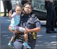  ?? Arkansas Democrat-Gazette/BENJAMIN KRAIN ?? A child waves to her mother as she is taken from the day care in Little Rock where a 57-year-old woman was killed in a drive-by shooting Thursday.