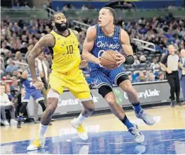  ?? JOHN RAOUX/AP PHOTOS ?? The Magic’s Aaron Gordon goes to the basket under pressure from the Pacers’ Kyle O’Quinn on Friday night at Amway Center.