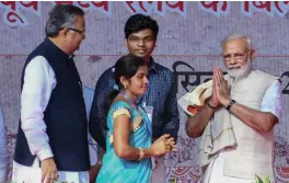  ?? — PTI ?? Prime Minister Narendra Modi is presented with a jacket and a shawl made from banana tree and lin seed ( locally known Alsi) at a farmers’ rally at Janjgir in Chhattisga­rh on Saturday as state chief minister Raman Singh looks on.