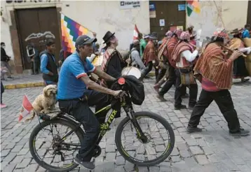  ?? RODRIGO ABD/AP ?? Peru protest: A demonstrat­or transporti­ng a dog on the back of his bicycle attends an anti-government march Thursday in Cusco, Peru. Protesters want new elections, the resignatio­n of President Dina Boluarte and the dissolutio­n of Congress. Boluarte succeeded Pedro Castillo after he was ousted and arrested for trying to dissolve Congress in December.