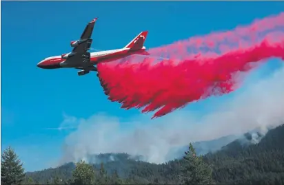  ?? ROBERT LEBLANC — U.S. FOREST SERVICE ?? Air tanker drops fire retardant near state Route 36 on Sunday. State Route 36 was closed from the Humboldt-Trinity county line to Bowman Road in Tehama County.