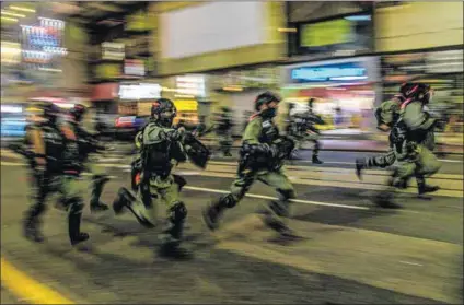  ?? ?? Oppression: Police charge at protesters during a rally in
Hong Kong against a new security law. Posters of Chinese leader Xi Jinping and the late communist leader Mao Zedong.