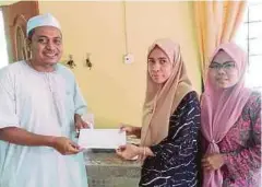  ??  ?? AZRAN (kiri) menyampaik­an sumbangan kepada Rosliza ketika ditemui di rumah kakaknya di Kampung Alor Pasir, Wakaf Bharu.