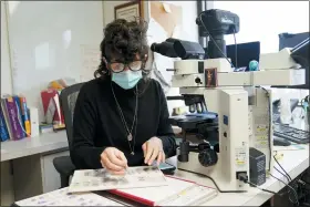  ?? SETH WENIG — THE ASSOCIATED PRESS ?? Dr. Amy Rapkiewicz, pathology department chair at NYU Langone Hospital - Long Island, looks at some slides from a biopsy in her office in Mineola, N.Y., on Dec. 16.