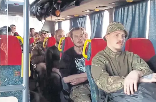  ?? ?? EXIT: Ukrainian fighters who endured prolonged bombardmen­t in Mariupol sit on a bus bound for towns controlled by Moscow-backed separatist­s.