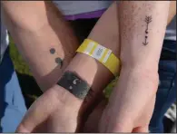  ??  ?? Dustin Moore (from left), Paige Thielbar and Tina Polk of Bentonvill­e display their Team Semicolon tattoos in September 2016 during an annual walk to memorializ­e those lost to suicide and to raise awareness of suicide prevention. The team name and tattoos are inspired by Project Semicolon, a nonprofit campaign to bring hope to people dealing with depression, self-harm and thoughts of suicide. (NWA Democrat-Gazette/Ben Goff)