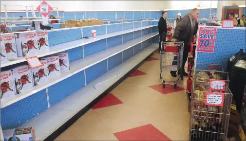  ?? Ernest A. Brown/The Call ?? Customers search the remaining items on the shelves inside the Benny’s store on Route 44 in Smithfield on Saturday, the last store open in Rhode Island. The store will be closing for good on today.