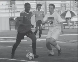  ?? STAFF PHOTO BY TED BLACK ?? North Point High School junior Hassan Turay looks to dribble past McDonough junior Francis Franch in the first half of Tuesday’s Southern Maryland Athletic Conference boys soccer game. McDonough scored first, but North Point dominated from there en route to a 6-1 victory over the visiting Rams.