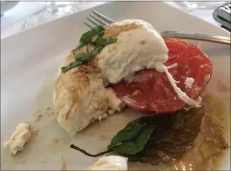  ??  ?? When cut into, the softer cheese inside of a burrata mozzarella naps the tomato of the Burrata Caprese Napoleon.