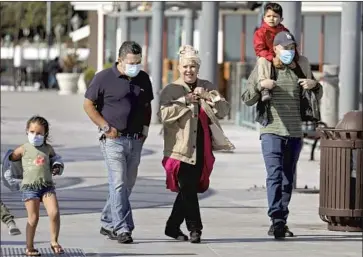  ?? GARY CORONADO Los Angeles Times ?? PEOPLE walk in Redondo Beach on Tuesday, a day when the CDC said fully vaccinated people did not need to wear a mask for many outdoor activities. The guidance ref lects the latest science on virus transmissi­on.